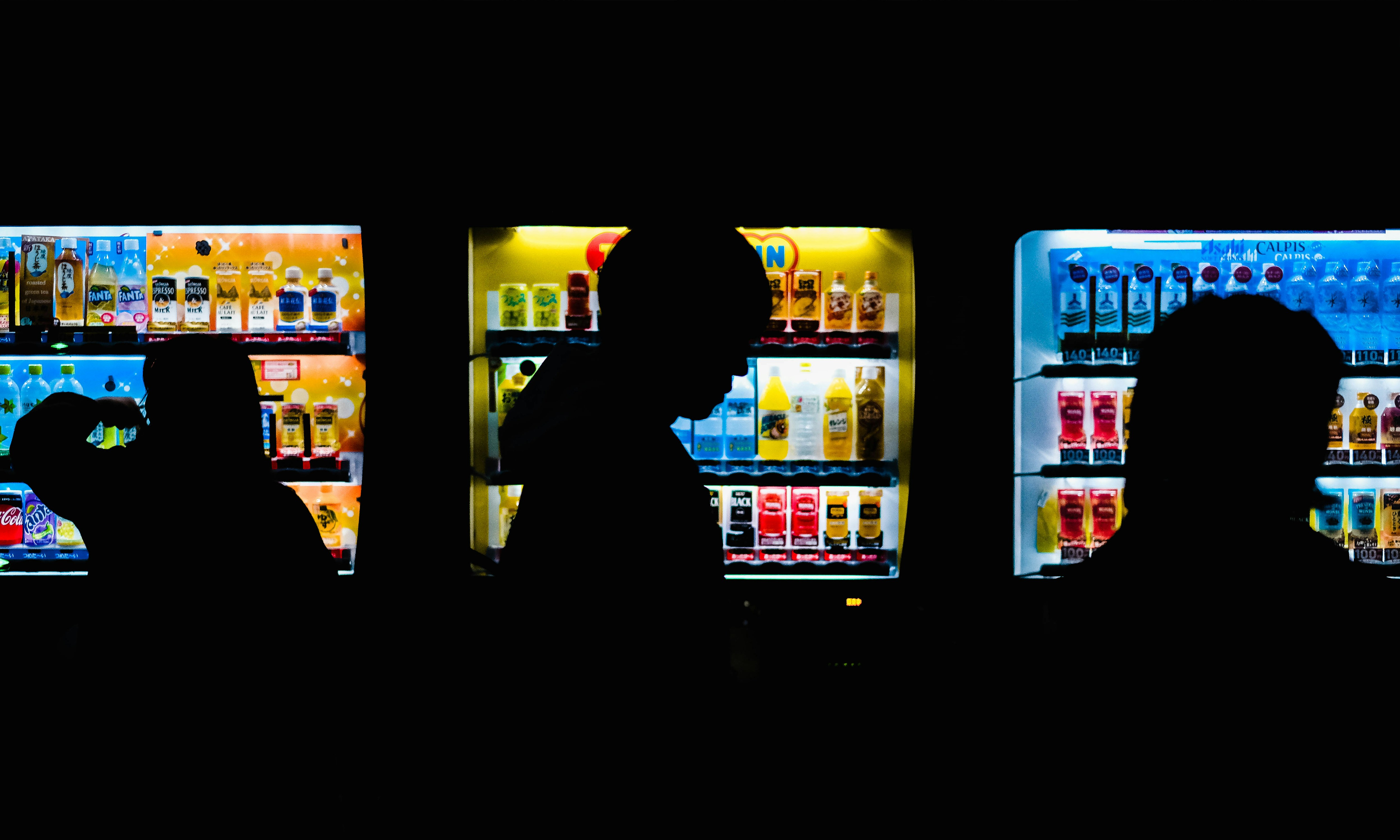 silhouette of people standing in front of commercial chillers